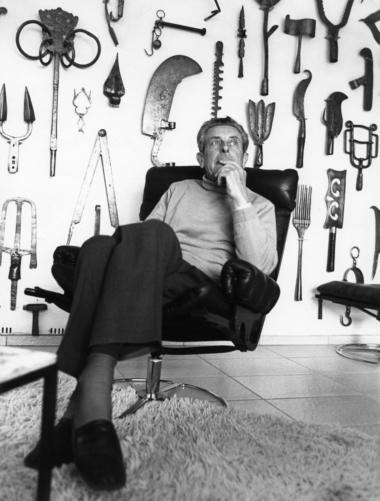 Louis Van Lint in his living room. Part of his tools collection covers the wall in the background.